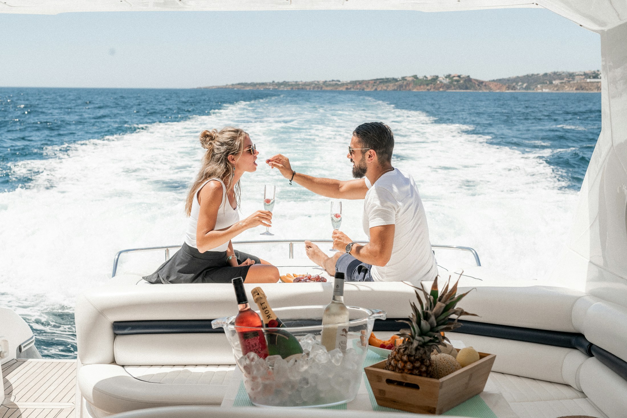 A couple sharing drinks on the aft deck of a private yacht