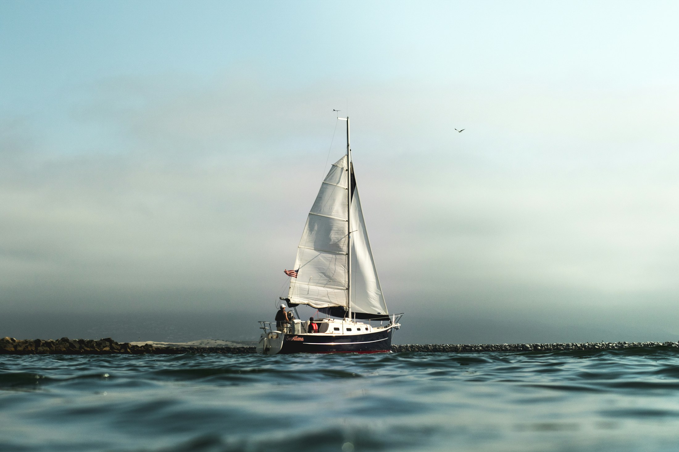 A sailing yacht approaching across calm open water